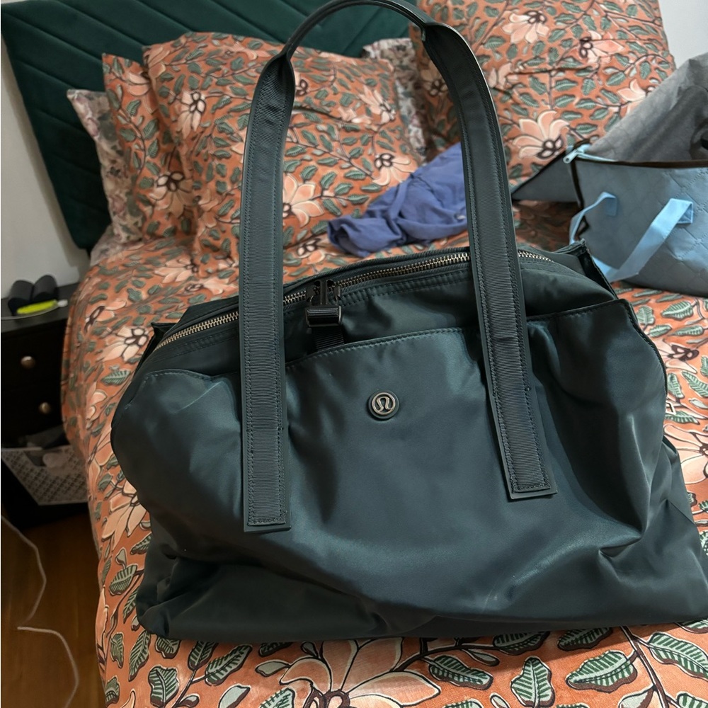 Teal Lululemon weekender bag with dirty clothes bag and hair tool holder.